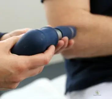 Close-up of a physiotherapist applying shock wave therapy to a patient’s elbow at Advance Physiotherapy Clinic in Chhatrapati Sambhajinagar (Aurangabad).
